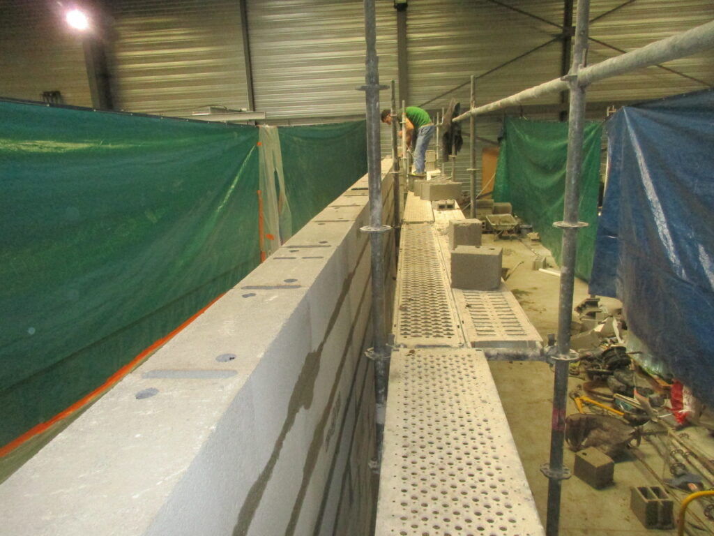 Mur en blocs béton monté sur échafaudage, arase soignée