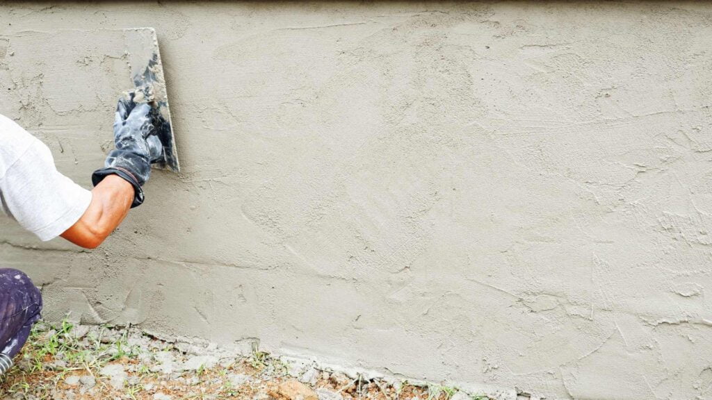 Application d'enduit projeté sur mur de clôture à Luynes