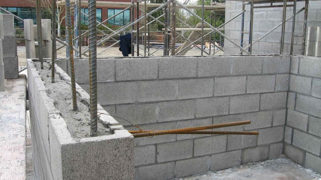 Maçonnerie de parpaings en cours de montage autour d'une ouverture, chantier en Provence