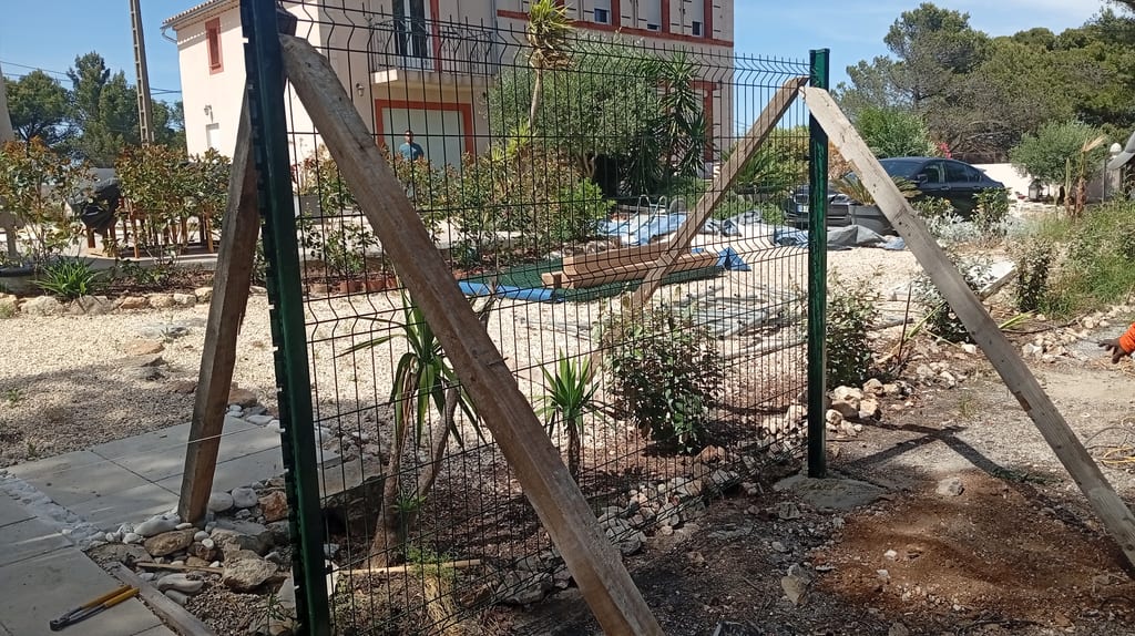 Panneaux de grillage rigide vert RAL 6005 étayés pendant la prise des plots béton — Les Cadeneaux, Les Pennes-Mirabeau, juin 2026