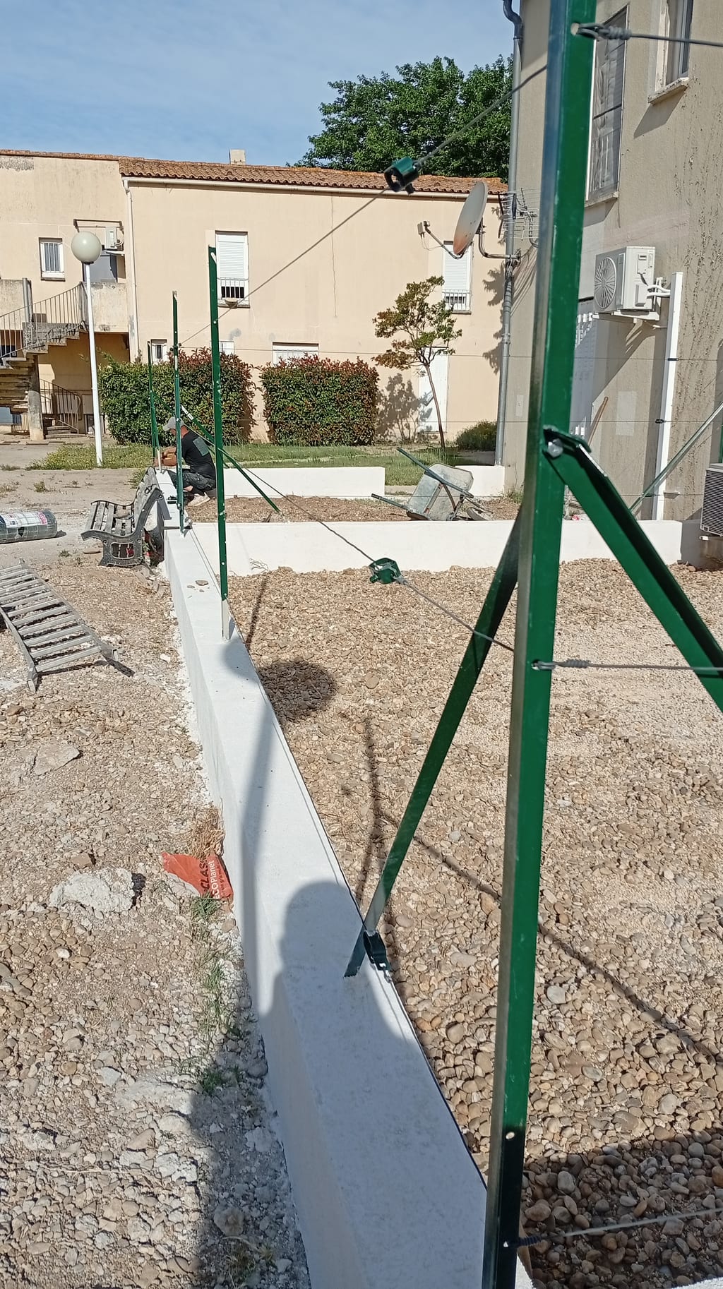 Poteau d'angle T50 contrebuté par une jambe de force sur muret